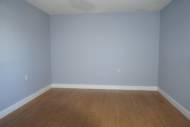 unfurnished room with hardwood / wood-style floors and a textured ceiling