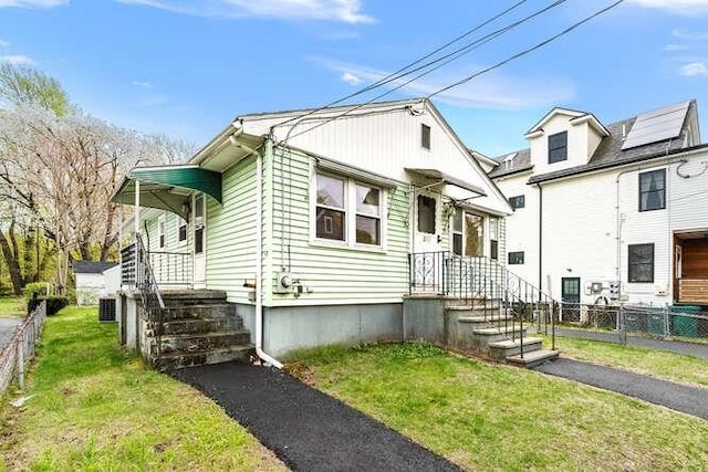 bungalow-style house with fence and a front yard