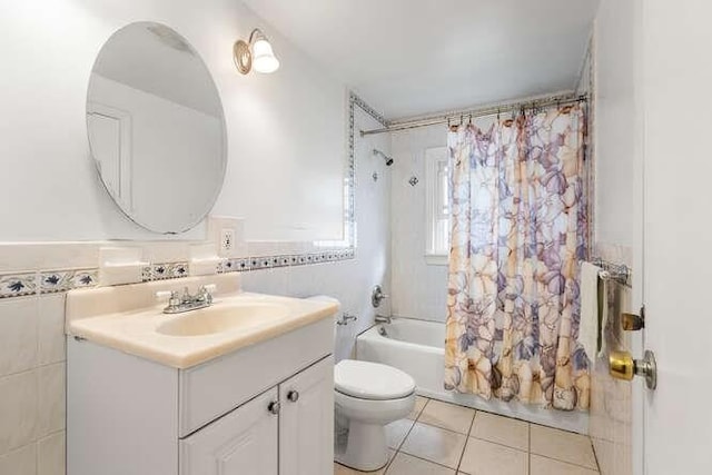 bathroom featuring tile walls, vanity, tile patterned floors, toilet, and shower / bath combo with shower curtain