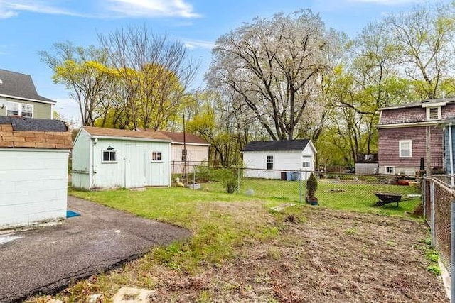 view of yard featuring fence, an outdoor structure, and a shed