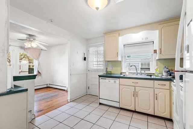kitchen featuring white dishwasher, dark countertops, ceiling fan, and a sink