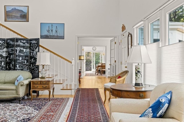 living room featuring healthy amount of natural light, stairway, and wood finished floors