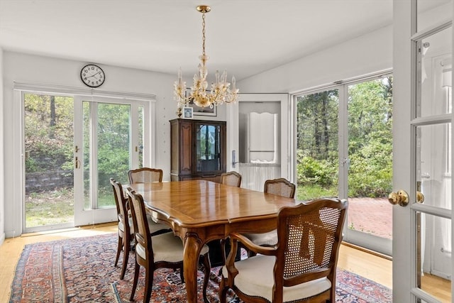 dining space with a chandelier and light wood-style floors