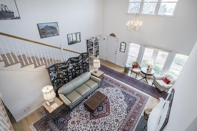 living room with a high ceiling, wood finished floors, and a chandelier