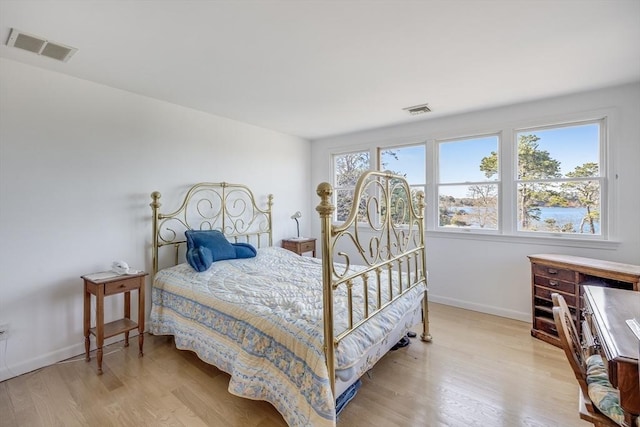 bedroom with light wood finished floors and baseboards