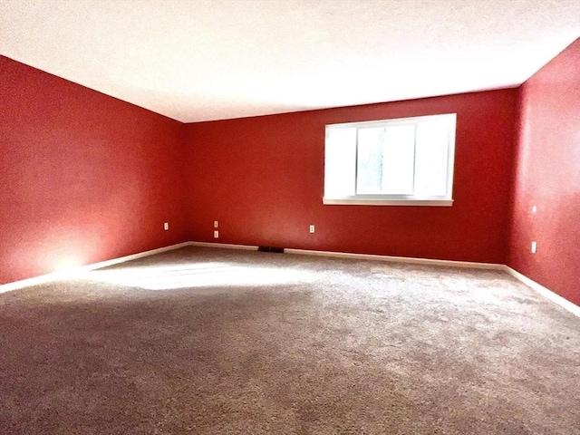 unfurnished room with carpet floors and a textured ceiling