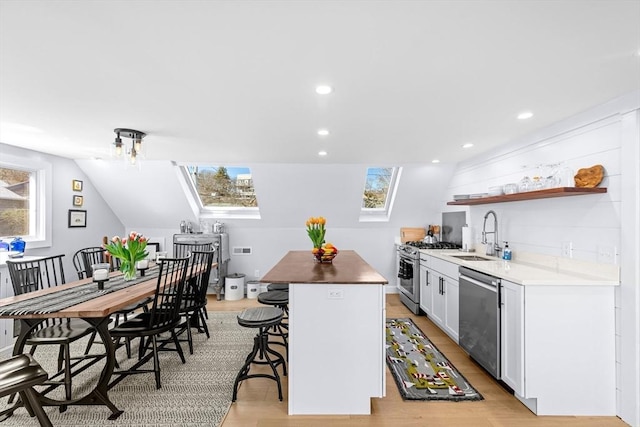 2111/2 Bradford St, Provincetown, MA 02657 - kitchen with appliances with stainless steel finishes, a sink, a skylight, a center island, and recessed lighting
