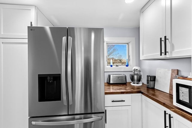 2111/2 Bradford St, Provincetown, MA 02657 - kitchen featuring stainless steel fridge with ice dispenser, butcher block counters, white microwave, and white cabinetry