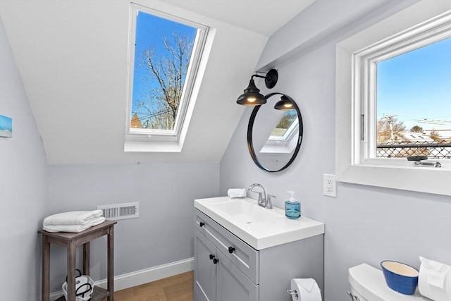 2111/2 Bradford St, Provincetown, MA 02657 - bathroom featuring wood finished floors, vanity, toilet, and vaulted ceiling