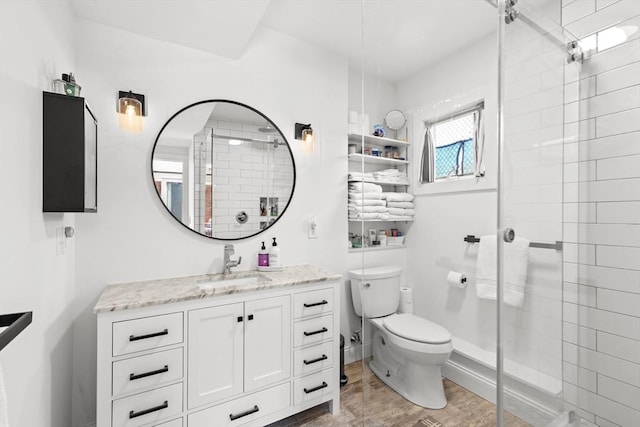 2111/2 Bradford St, Provincetown, MA 02657 - bathroom featuring toilet, a tile shower, vanity, and wood finished floors