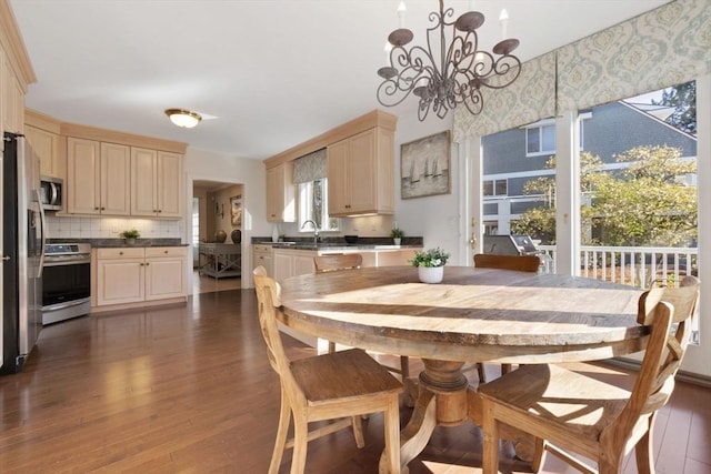 dining area featuring dark wood-type flooring and a notable chandelier