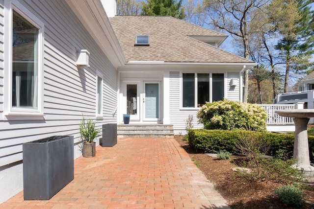 doorway to property featuring a shingled roof
