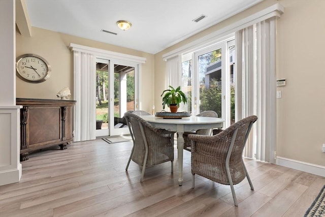 dining area featuring visible vents and light wood-style flooring