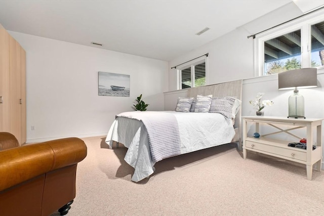 carpeted bedroom with visible vents and multiple windows