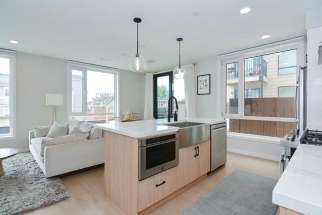 457 W Broadway Unit 209, Boston, MA 02127 - kitchen featuring light brown cabinets, dishwasher, open floor plan, light countertops, and recessed lighting
