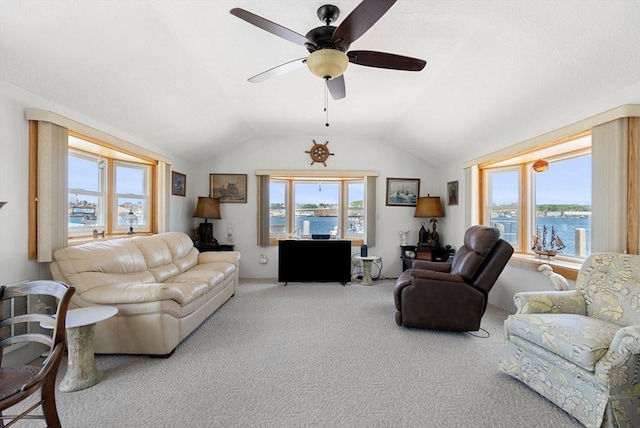 living room featuring a ceiling fan, carpet, vaulted ceiling, and plenty of natural light