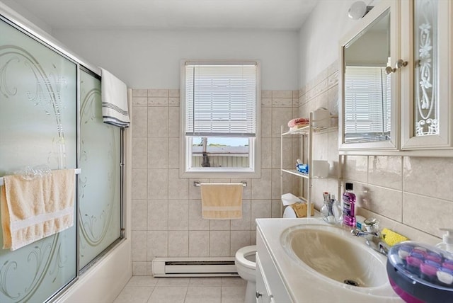 full bath featuring enclosed tub / shower combo, tile patterned floors, vanity, a baseboard heating unit, and tile walls