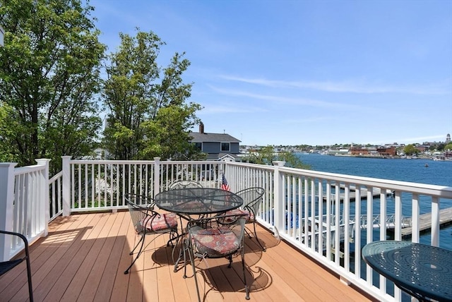 wooden deck featuring outdoor dining space and a water view