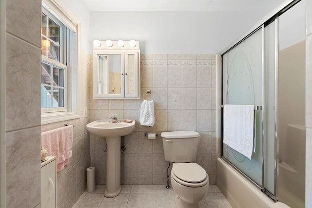 full bath with toilet, tile patterned flooring, enclosed tub / shower combo, and tile walls