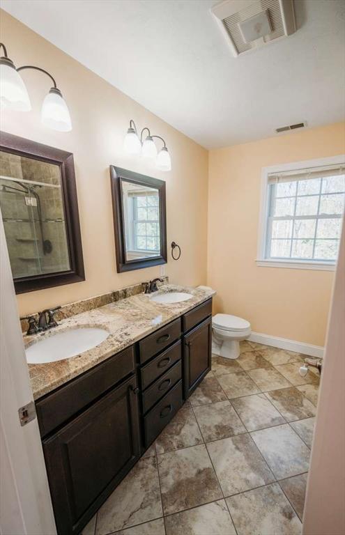 20 Warner Rd, Townsend, MA 01469 - bathroom with a sink, double vanity, tiled shower, and visible vents