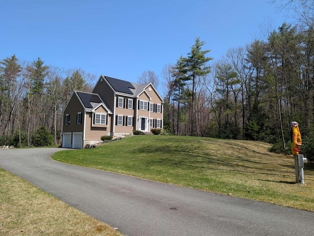 20 Warner Rd, Townsend, MA 01469 - view of front of home with an attached garage, roof mounted solar panels, a front yard, and aphalt driveway