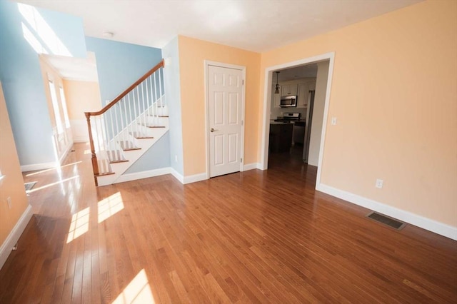 20 Warner Rd, Townsend, MA 01469 - unfurnished living room featuring visible vents, wood-type flooring, baseboards, and stairway