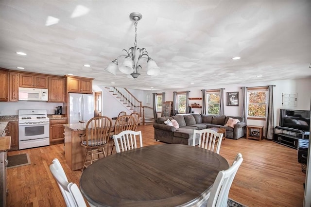 dining space featuring light wood-type flooring, a notable chandelier, and a healthy amount of sunlight