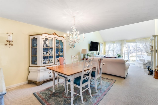 dining room with vaulted ceiling, light colored carpet, and a chandelier