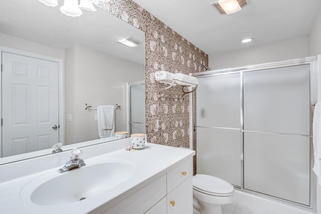 bathroom with vanity, an enclosed shower, and toilet