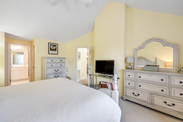 carpeted bedroom featuring connected bathroom and vaulted ceiling