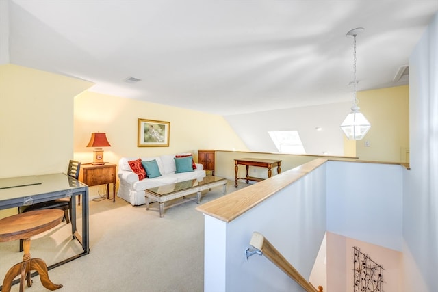 living room with light colored carpet and vaulted ceiling with skylight