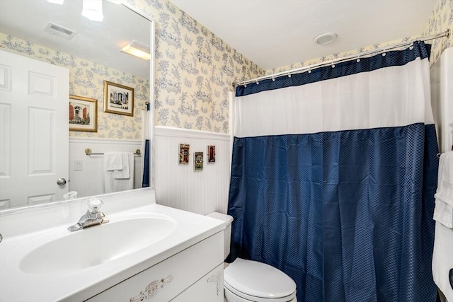 bathroom featuring a shower with curtain, vanity, and toilet