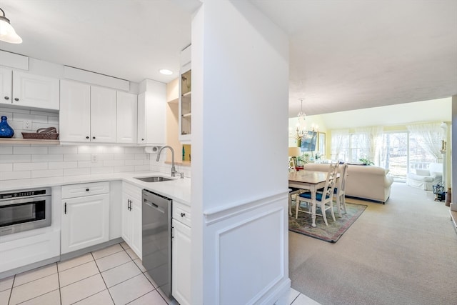 kitchen with sink, white cabinets, decorative backsplash, stainless steel dishwasher, and wall oven