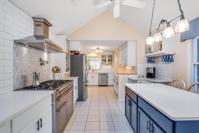 kitchen with blue cabinetry, ventilation hood, light tile patterned floors, appliances with stainless steel finishes, and white cabinets