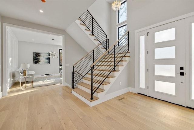 entrance foyer with a notable chandelier and light hardwood / wood-style flooring