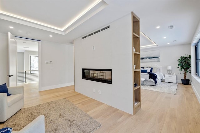 living room featuring a large fireplace and light wood-type flooring