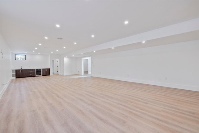 unfurnished living room featuring light hardwood / wood-style flooring and indoor bar