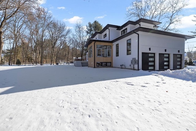 snow covered property with a garage