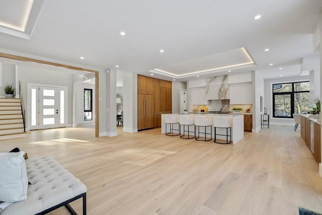 living room with light hardwood / wood-style flooring and a raised ceiling