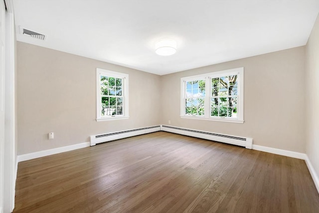27 Lantern Ln, Arlington, MA 02474 - spare room featuring baseboard heating, healthy amount of natural light, baseboards, and wood finished floors