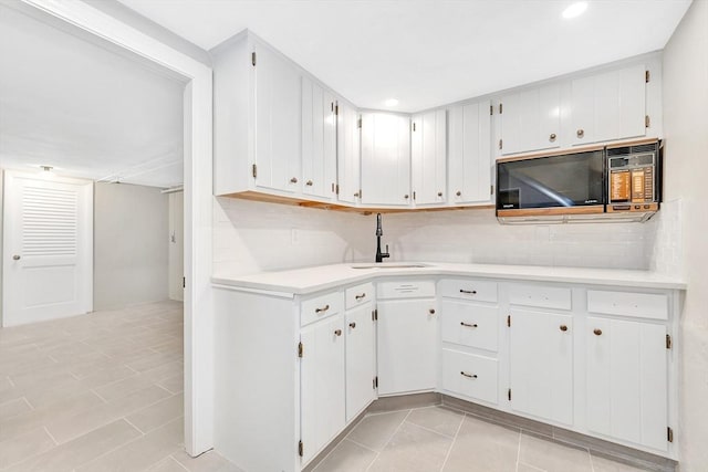 27 Lantern Ln, Arlington, MA 02474 - kitchen featuring black microwave, a sink, light tile patterned floors, tasteful backsplash, and recessed lighting