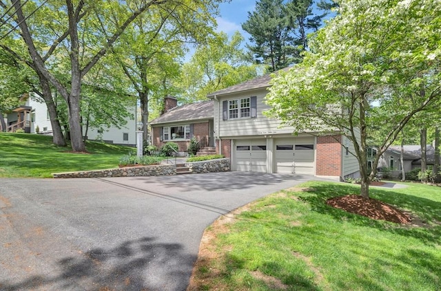 27 Lantern Ln, Arlington, MA 02474 - split level home with driveway, brick siding, an attached garage, and a front yard