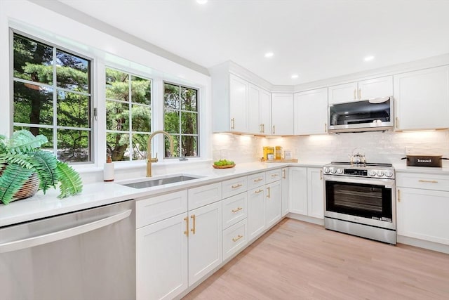 27 Lantern Ln, Arlington, MA 02474 - kitchen with appliances with stainless steel finishes, a sink, light countertops, backsplash, and recessed lighting