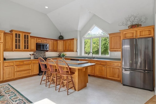 7 Humiston Cir, Westford, MA 01886 - kitchen with freestanding refrigerator, black microwave, a sink, a kitchen breakfast bar, and high vaulted ceiling