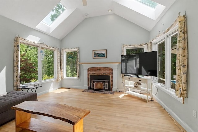 7 Humiston Cir, Westford, MA 01886 - living area featuring a skylight, healthy amount of natural light, a wood stove, high vaulted ceiling, and wood finished floors