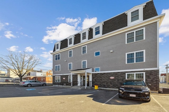 view of building exterior featuring cooling unit and uncovered parking