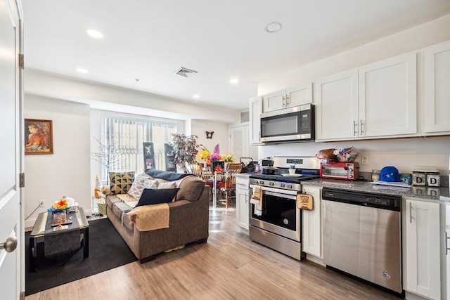 kitchen featuring stainless steel appliances, light hardwood / wood-style floors, and white cabinets