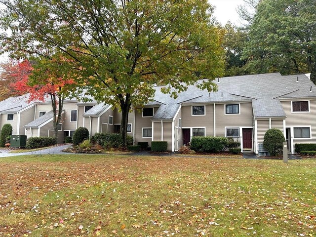 view of front of house featuring central AC unit and a front lawn