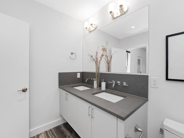 bathroom with wood-type flooring, tasteful backsplash, toilet, and vanity