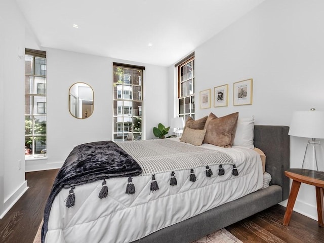 bedroom with multiple windows and dark hardwood / wood-style flooring